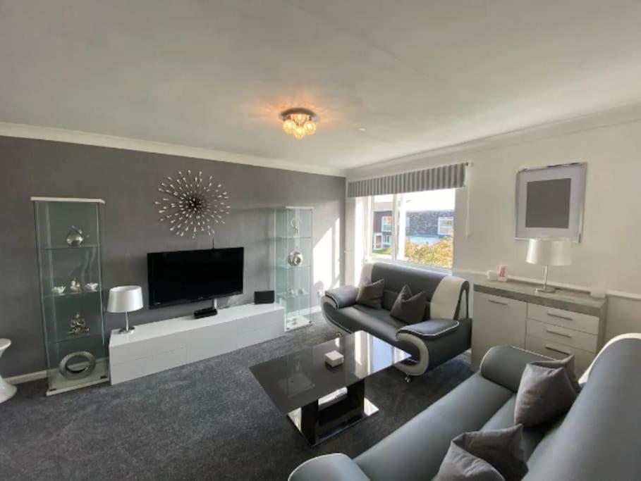 a living room with a couch and a tv at Vibrant 1st Floor Apartment in Cramlington