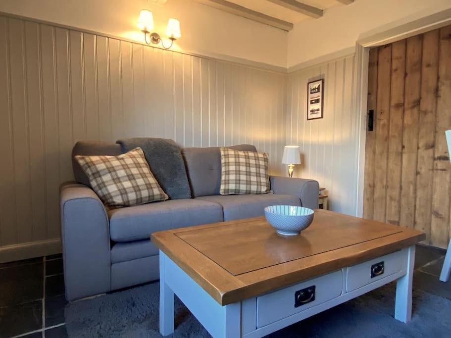 uma sala de estar com um sofá e uma mesa de centro em Shardlow Cottage em Derby