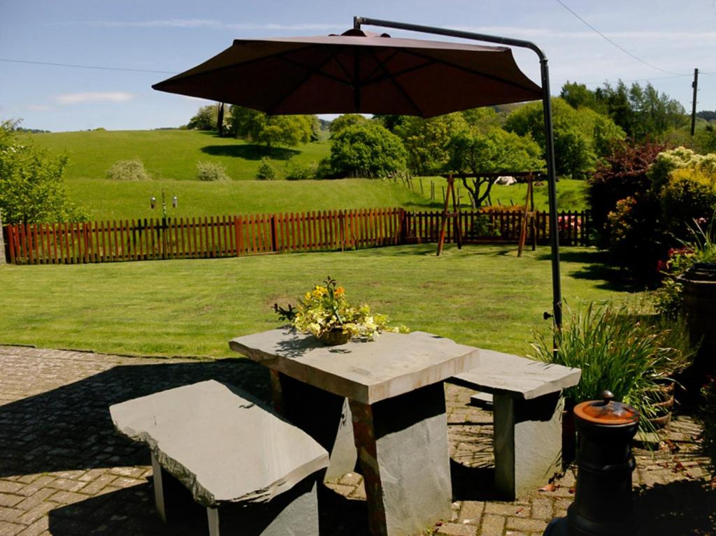 a picnic table with an umbrella and two chairs at 1 Bed in Hawkshead Village LLH16 in Hawkshead