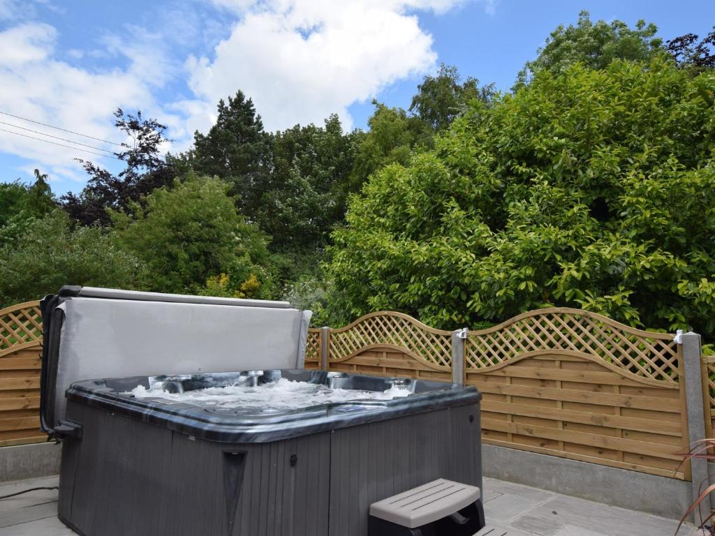 a hot tub on a patio next to a wooden fence at 1 Bed in Thaxted 51222 in Thaxted
