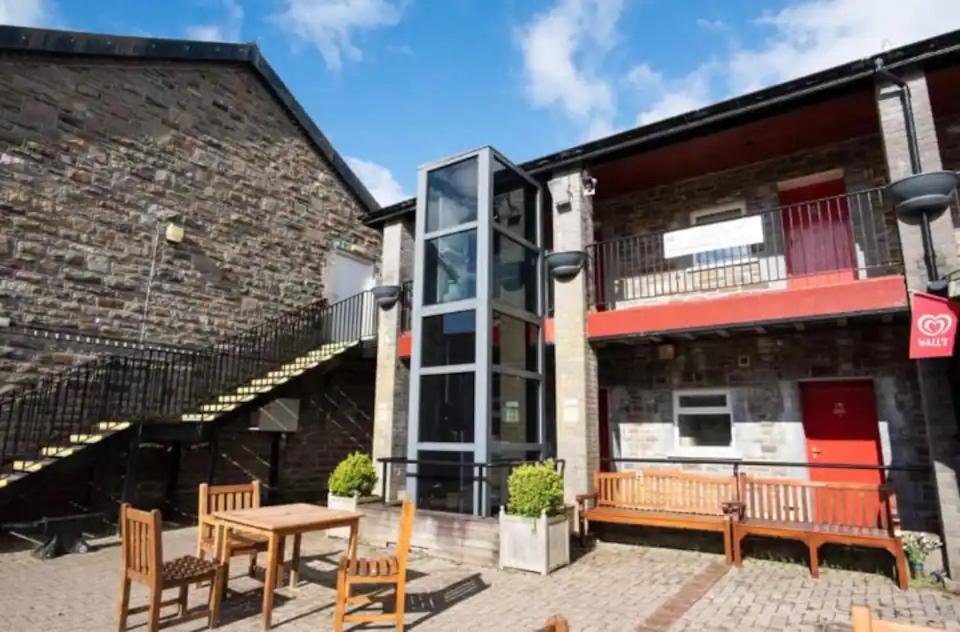 a patio with a table and chairs in front of a building at DARE VALLEY ACCOMMODATION in Aberdare