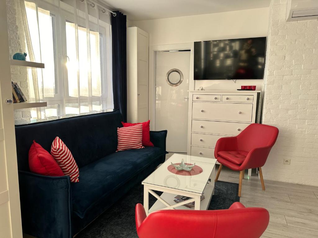 ヤストシェンビャ・グラにあるAmko Style Apartamenty Przystań 26 Willa Nordのリビングルーム(黒いソファ、赤い椅子付)