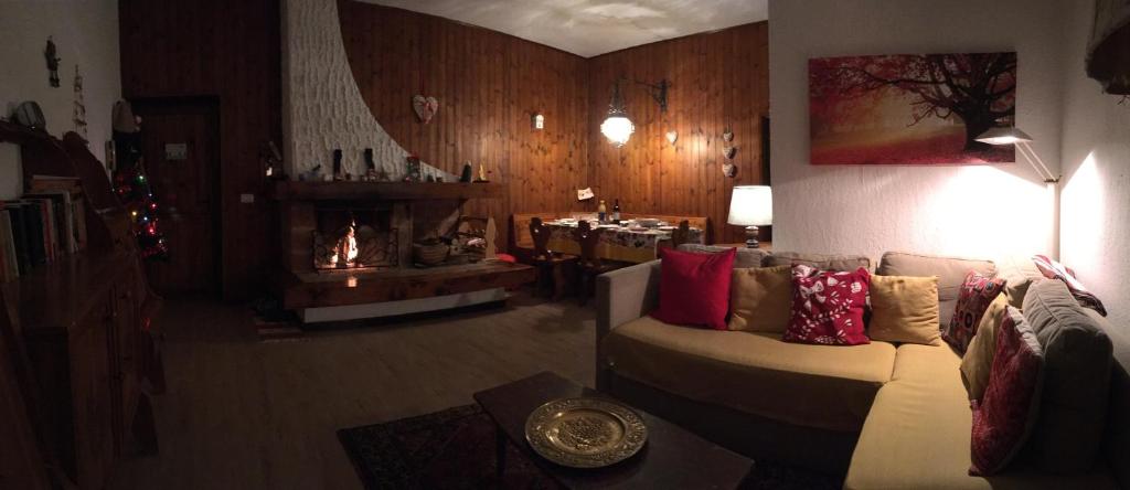 sala de estar con sofá y chimenea en Grazioso appartamento, en Cassina Valsassina