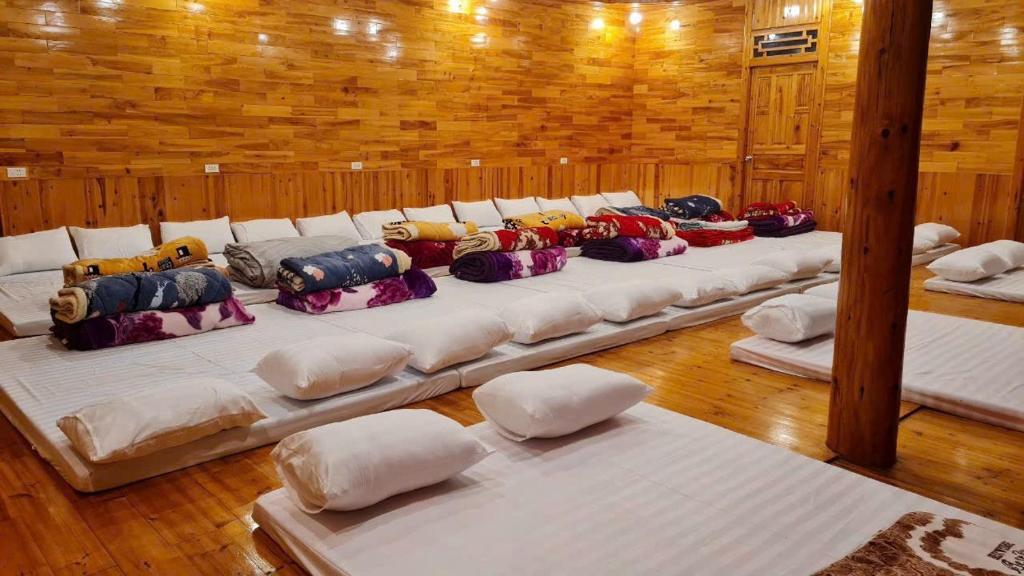 a row of pillows sitting on a bed in a room at Farmstay alenh Lùng Phình in Lao Cai