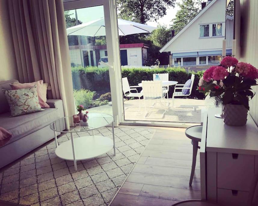 salon z kanapą i stołem z kwiatami w obiekcie Eget hus i Örgryte. Göteborgs bästa läge! w Göteborgu