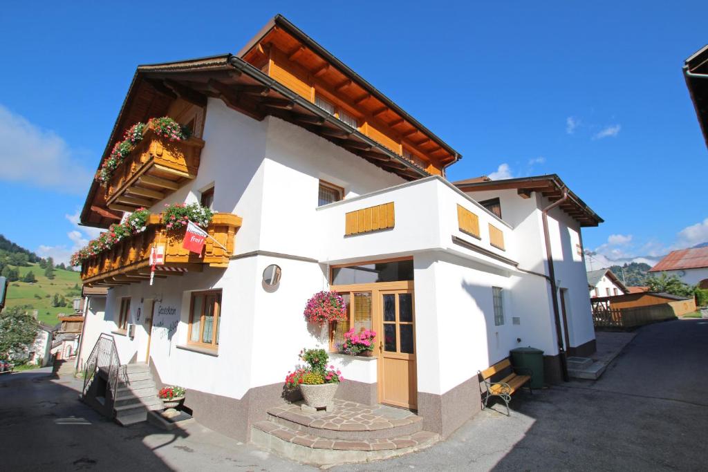 a white building with flowers in the window at Gästeheim Anni Winkler in Nauders