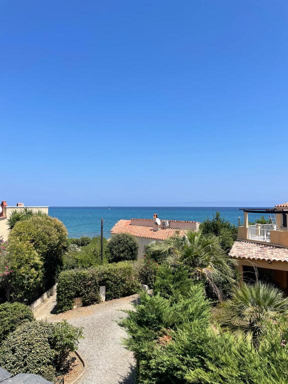 Elle offre une vue sur le jardin et l'océan en arrière-plan. dans l'établissement RESIDENCE LA PLAGE Pieds dans l'eau Belle Vue mer, à Linguizzetta