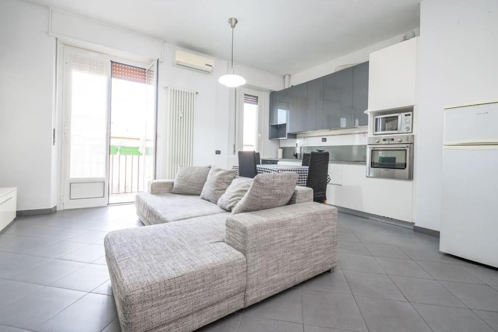 Il comprend un salon avec un canapé et une cuisine. dans l'établissement Grazioso appartamento in Bicocca con AC e Wi-fi, à Milan