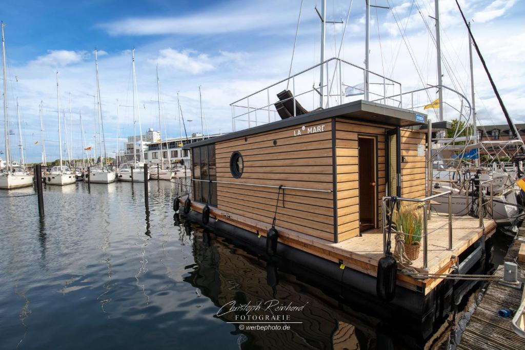 een kleine houten boot in het water bij Hausboot Seepferdchen in Heiligenhafen