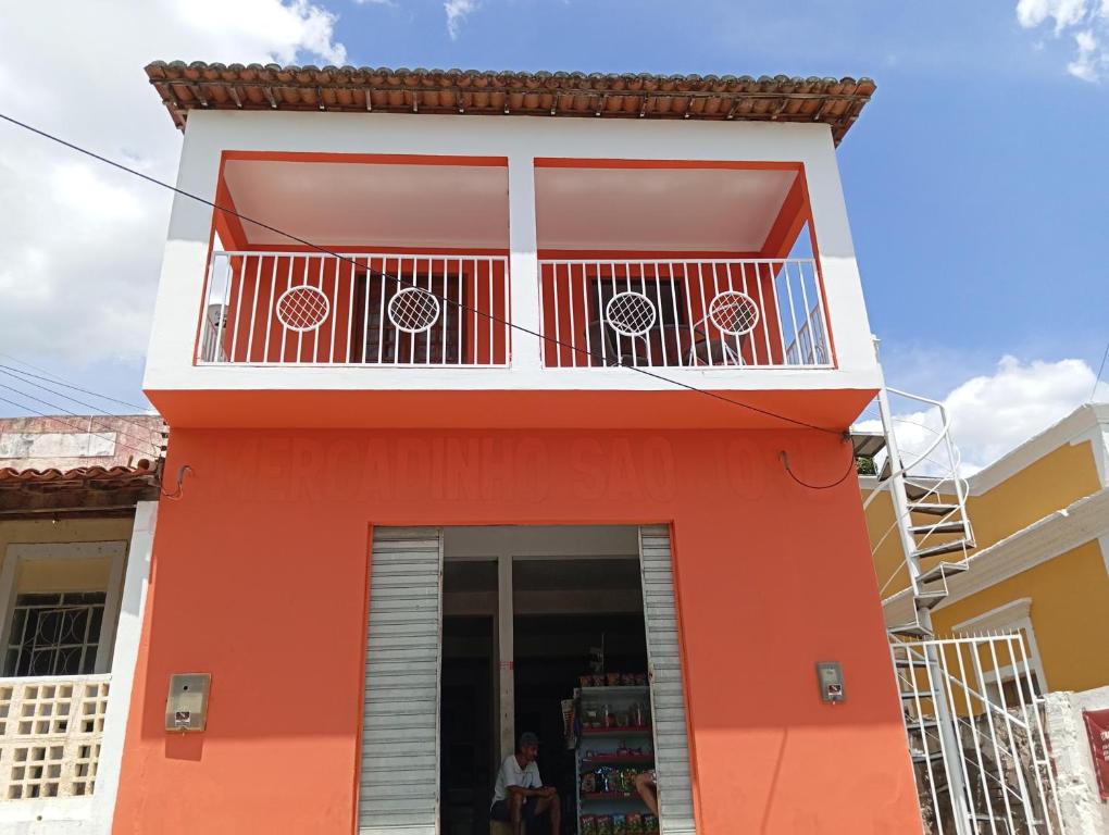a red building with a balcony at Casa Bela vista São José in Piranhas