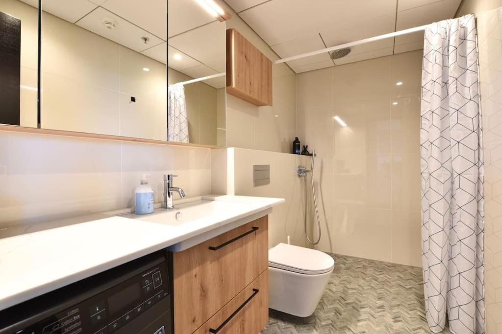 a bathroom with a sink and a toilet and a shower at Amazing High-Rise 1BR with 11th Floor Views in Tallinn
