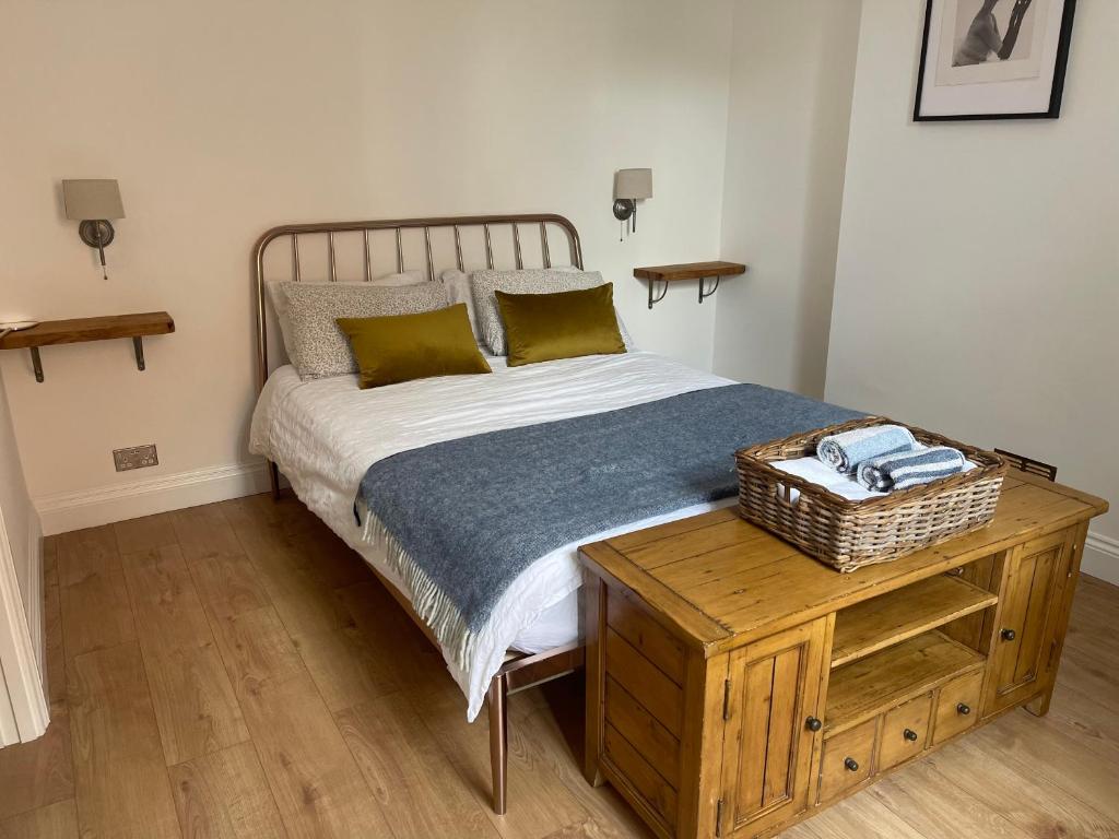 a bedroom with a bed and a table with a basket on it at Bright new flat in Battersea in London
