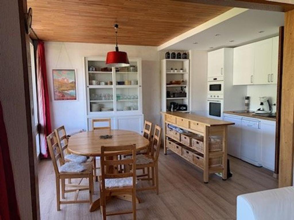 cocina y comedor con mesa de madera y sillas en Appartement Vars, 1 pièce, 6 personnes - FR-1-330B-29 en Vars