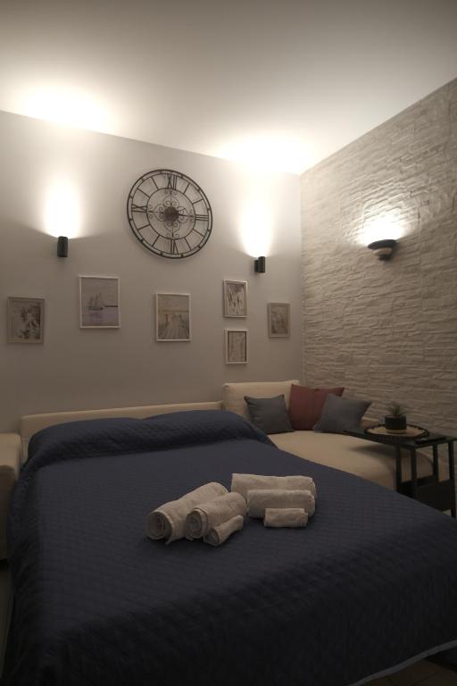 ポッツオーリにあるOdeMar Apartmentのベッドとタオル2枚のある寝室