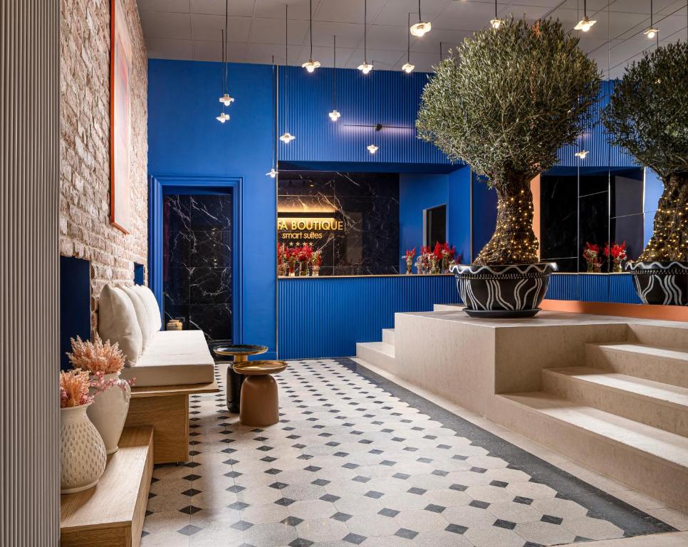 a lobby with blue walls and stairs and potted plants at Siesta Boutique Smart Suites in Cluj-Napoca