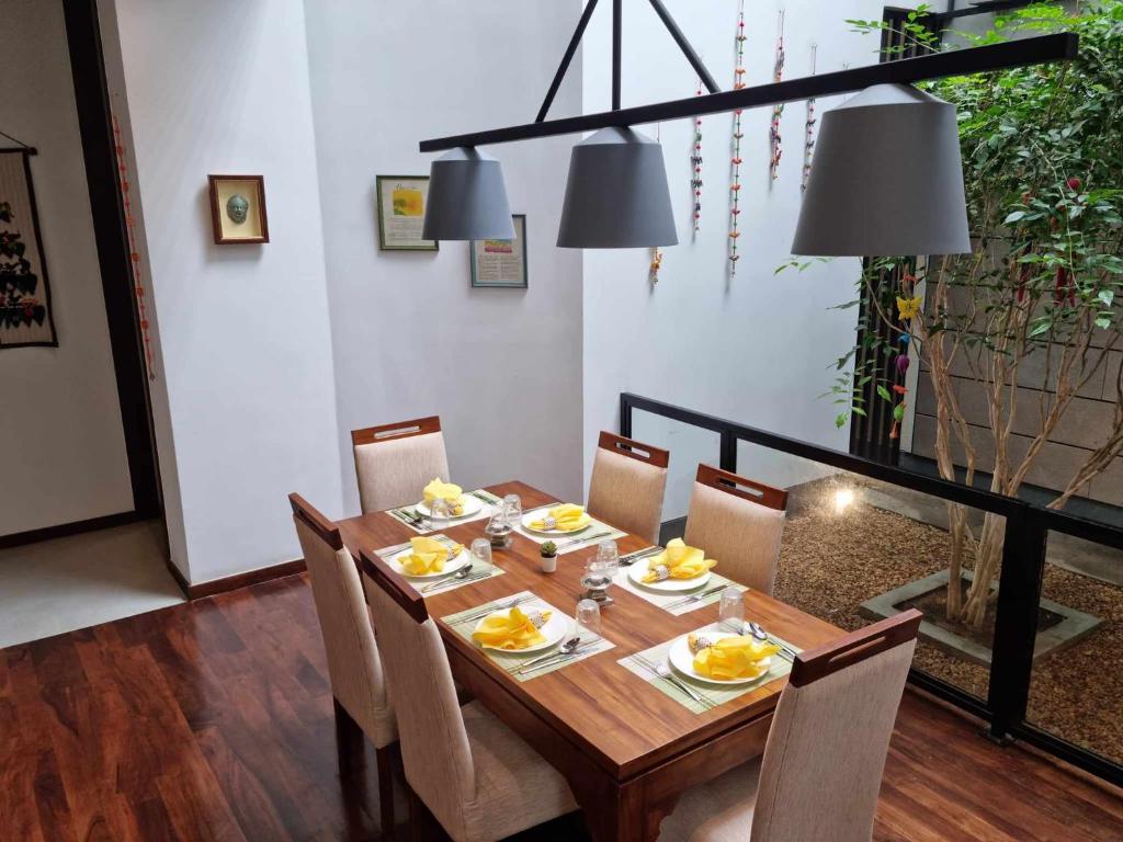 a dining room with a wooden table and chairs at Still Waters - A Cottage by the Lake! in Boralesgamuwa