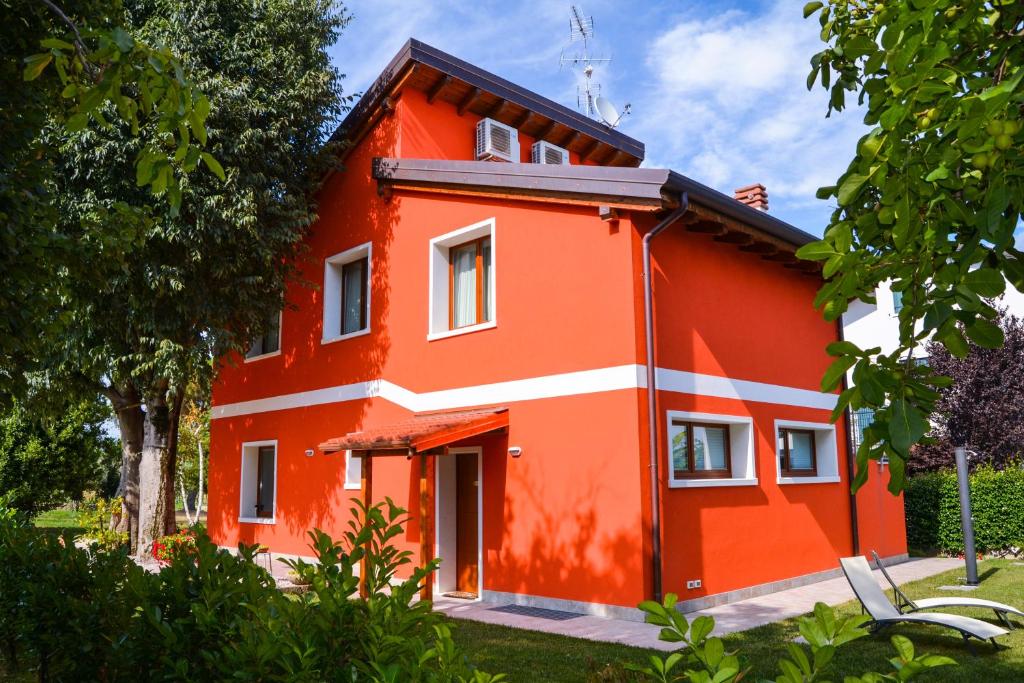 a red house with a white stripe on it at Agriturismo Ca' La Pergola in Verona