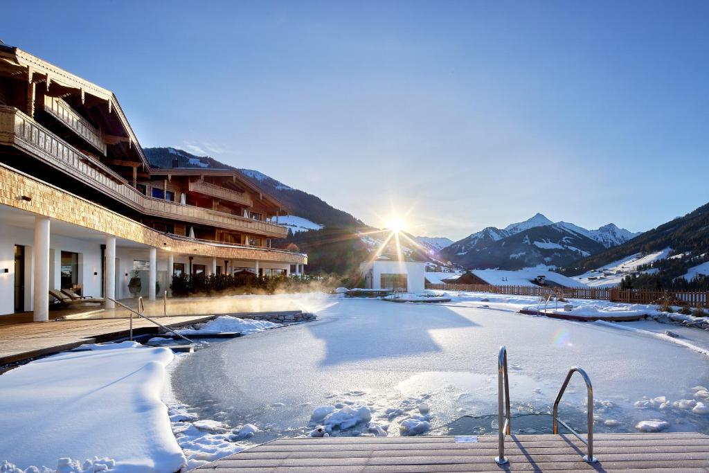 Blick auf einen gefrorenen See vor einem Gebäude in der Unterkunft Der Böglerhof - pure nature spa resort in Alpbach