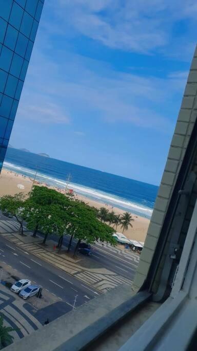 una ventana de un edificio con vistas a la playa en Apartamento lateral mar en Río de Janeiro