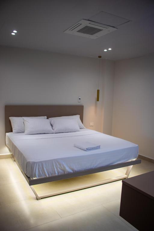 1 cama blanca grande en una habitación con luces en Hotel Amazonas Suite , suite lujosa en Nueva Loja