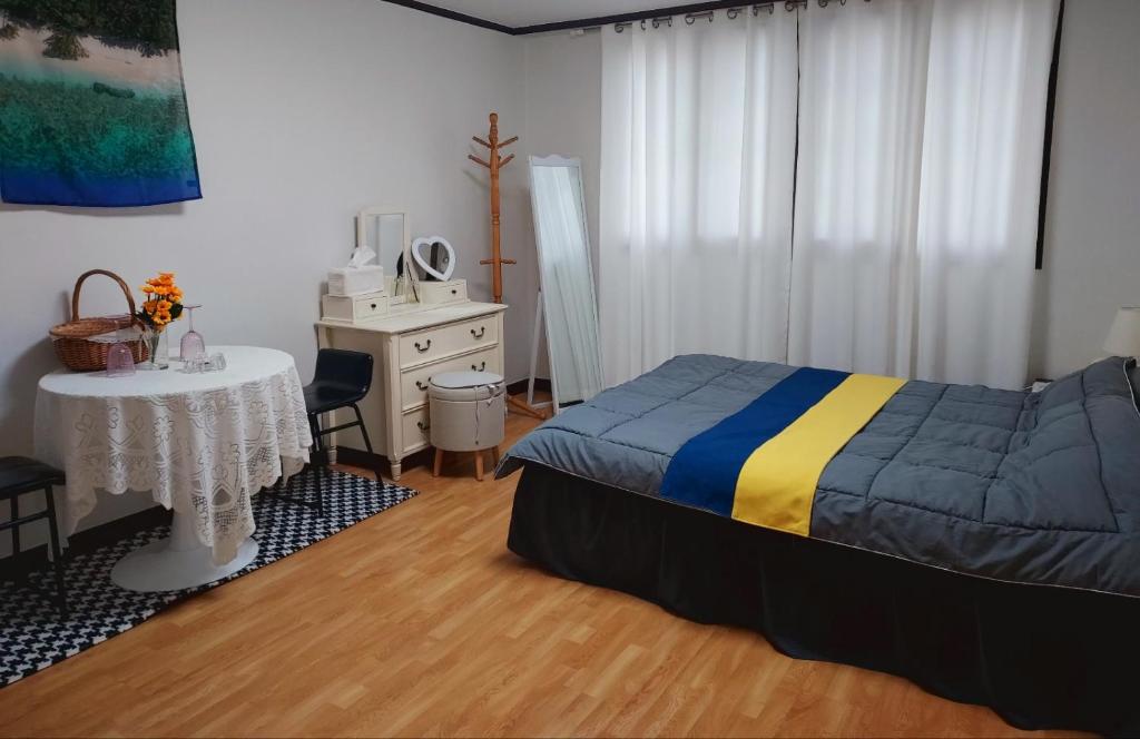 a bedroom with a bed and a desk and a table at Atti in Pyeongtaek
