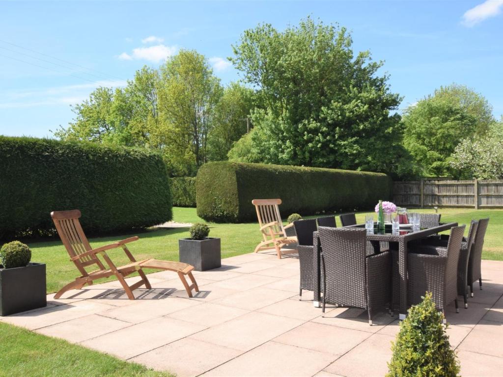 a patio with chairs and a table in a garden at 3 Bed in Fakenham 56661 in Whissonsett