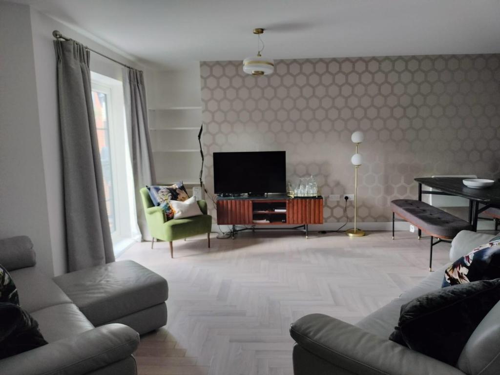 a living room with a couch and a television at Farnborough central in Farnborough