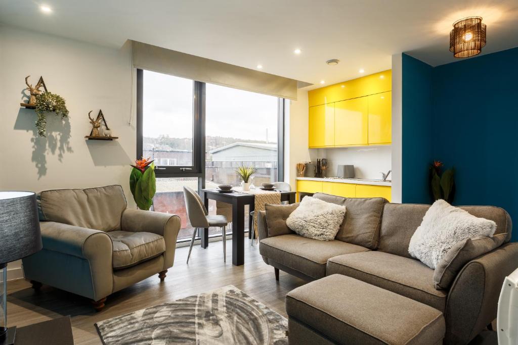 a living room with a couch and chairs and a table at Brand New Studio Apartment in Sheffield in Sheffield