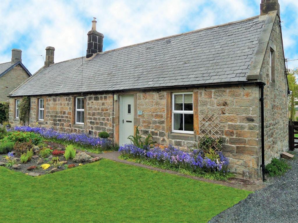 an old stone house with a garden in front of it at 2 Bed in Nr Amble CN049 in Acklington