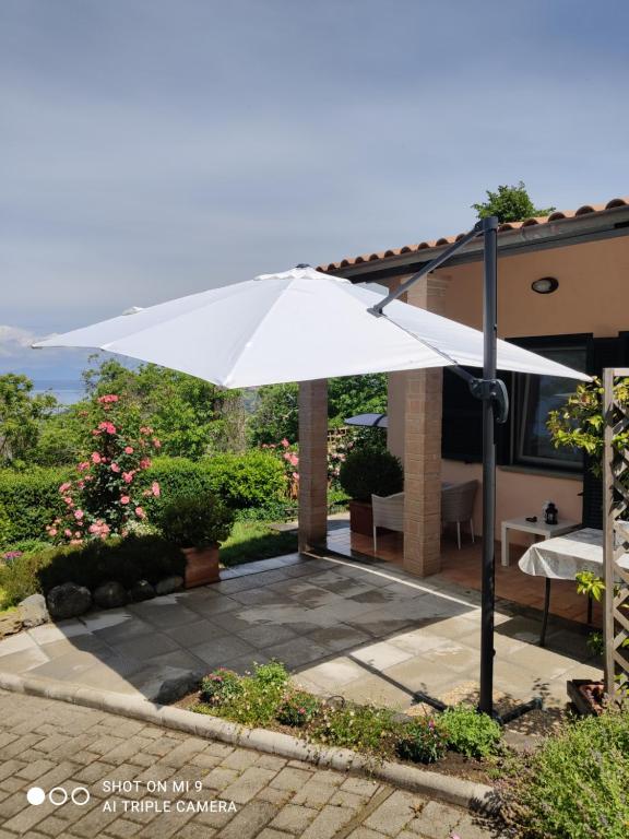 un paraguas blanco delante de una casa en Un Giardino sul Lago, en Montefiascone