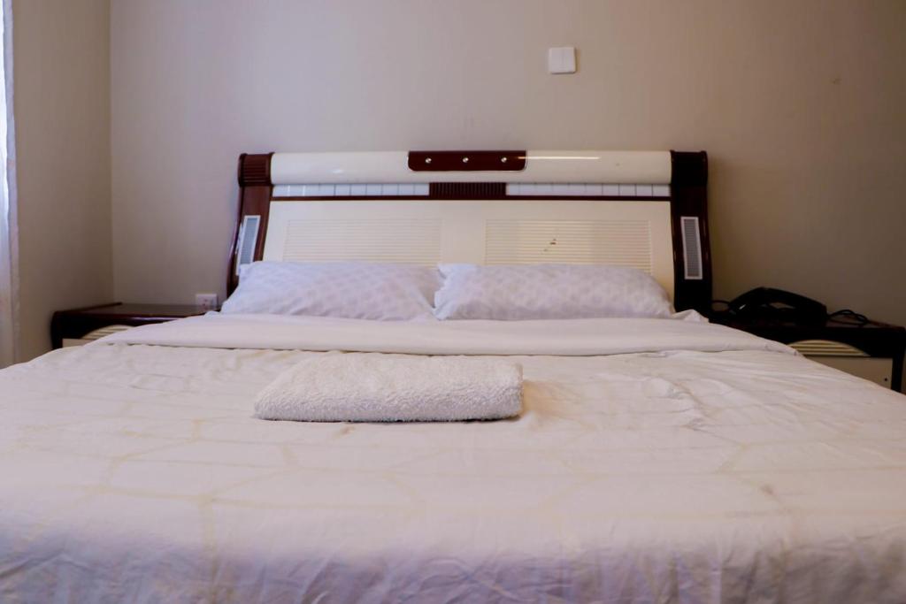 uma grande cama branca com duas toalhas em At Freddy's with free transport from JKIA em Nairobi