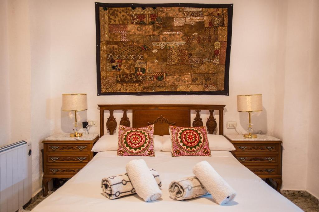 um quarto com uma cama com almofadas e um quadro na parede em Moorish house in Heart of albayzin em Granada