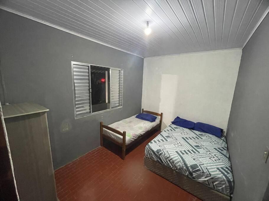 Habitación pequeña con cama y ventana en Casa para temporada em um paraíso tropical en Cananéia
