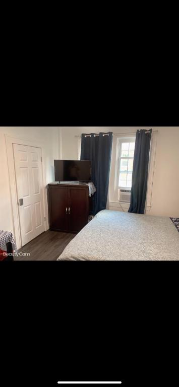 - une chambre avec un lit et une fenêtre avec des rideaux bleus dans l'établissement NICE BEDROOM NEXT JOHNS HOPKIN UNIVERSITY, à Baltimore