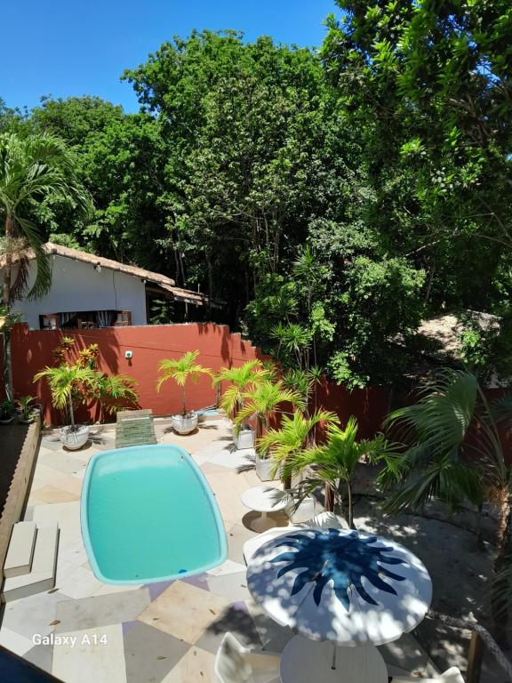 eine Terrasse mit zwei blauen Sonnenschirmen und einem Pool in der Unterkunft Caçadores de Aventuras Flats in Pipa
