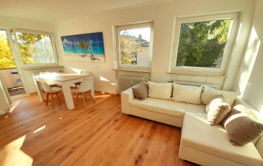 a living room with a white couch and a table at City Apartment Starnberg in Starnberg