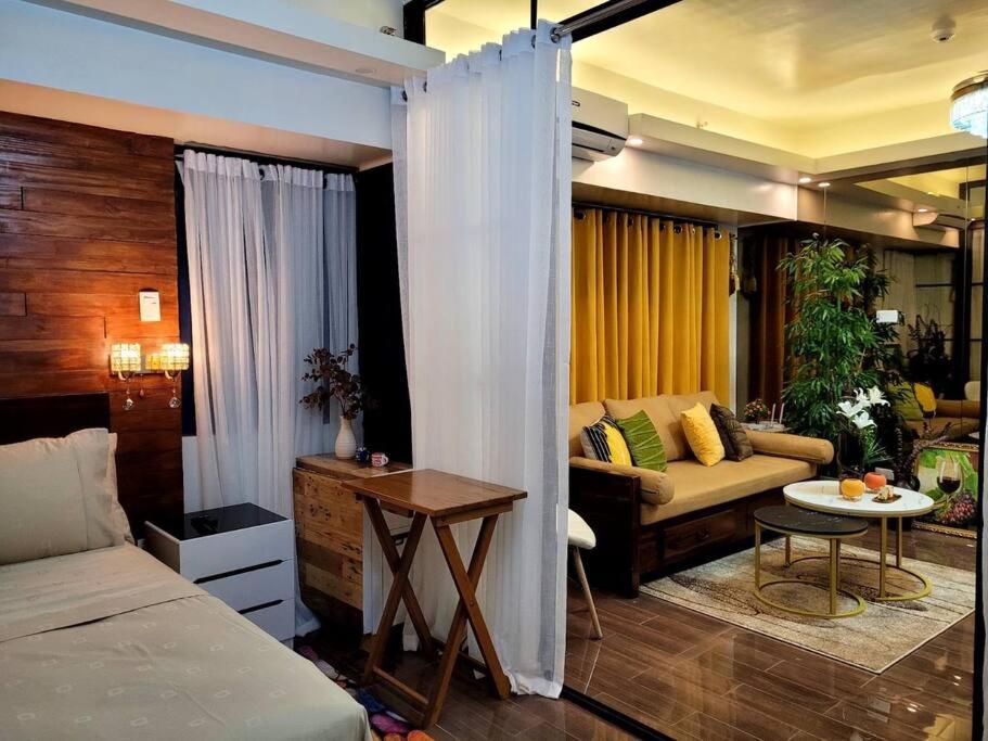 a bedroom with a bed and a couch and a table at Lady Di Suite in Makati in Manila