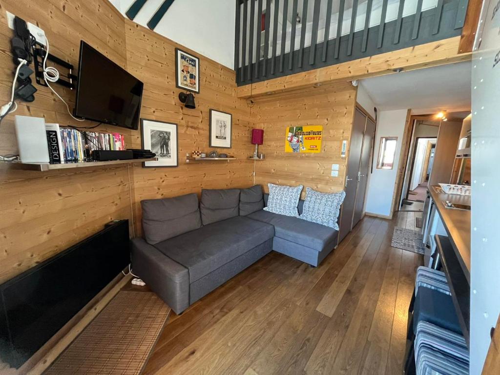 een woonkamer met een bank en een tv bij Ski Sun in L'Alpe-d'Huez