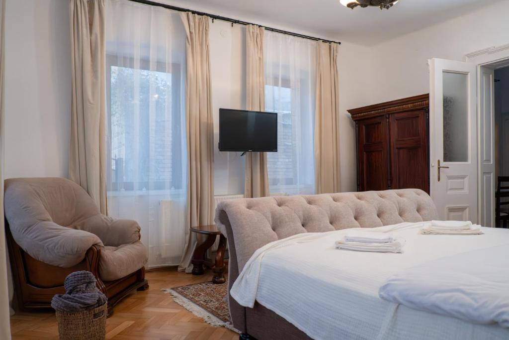 a bedroom with a bed and a chair and a television at Casa Puscariu in Braşov