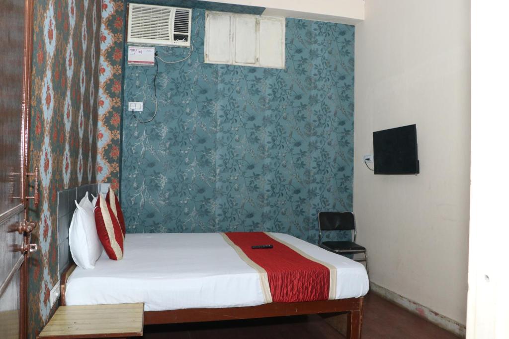1 dormitorio con cama y pared verde en hotel new agarwal, en Jhunjhunūn