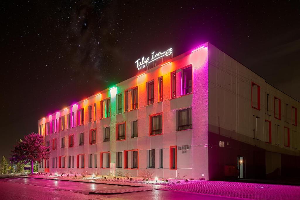 un edificio con luces de colores por la noche en Tulip Inn Żyrardów, en Żyrardów