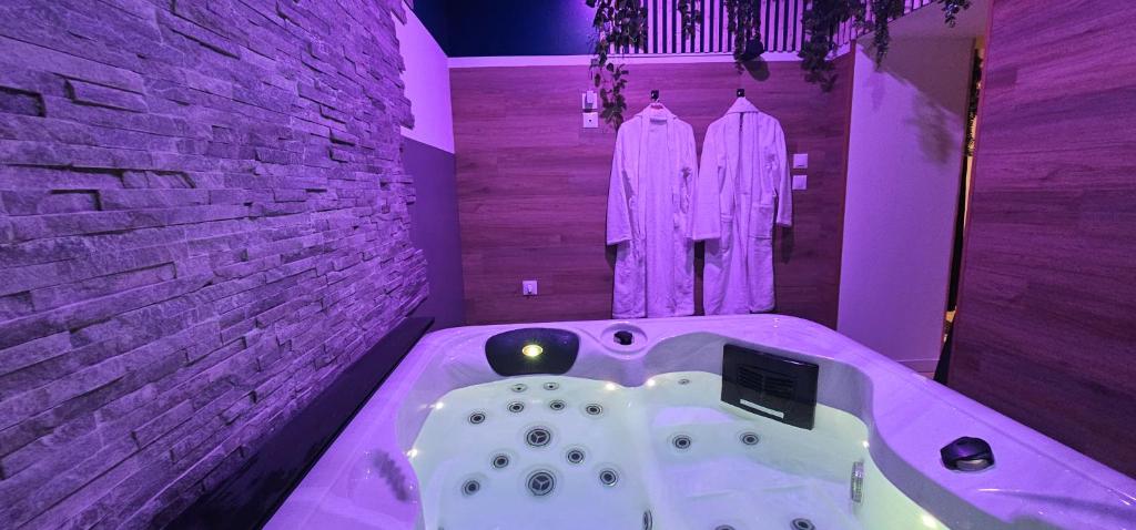 La salle de bains est pourvue d'une baignoire avec un éclairage violet. dans l'établissement Le Clos Maldier - Gîte Les Ecureuils, à Laon