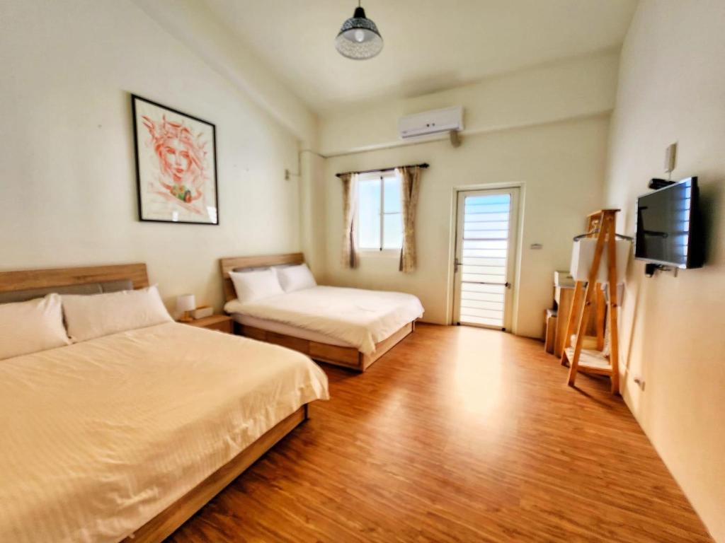 ein Hotelzimmer mit 2 Betten und einem TV in der Unterkunft Vuluq in Shoufeng