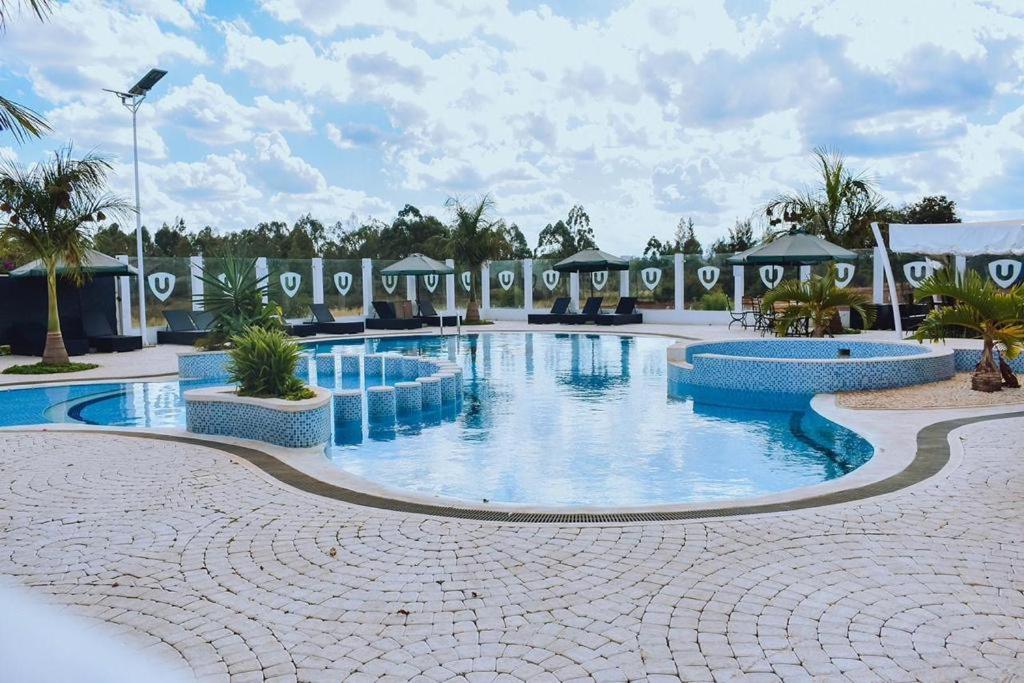 una grande piscina in un resort con palme di Sweet 2 Bedroom Tatu City a Nairobi