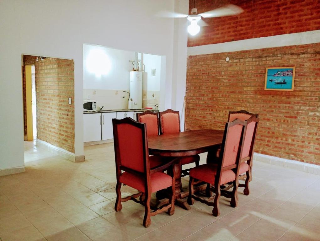 - une salle à manger avec une table et des chaises en bois dans l'établissement STELLA MARIS, à Las Grutas