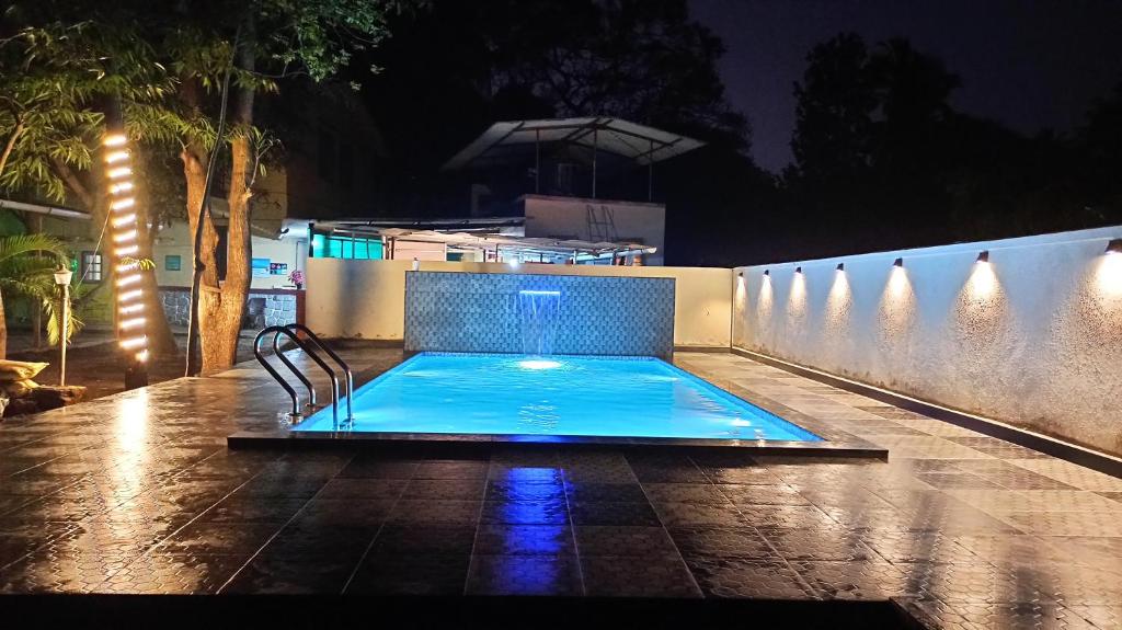 a swimming pool in a backyard at night at Kamal Homes in Kīhīm