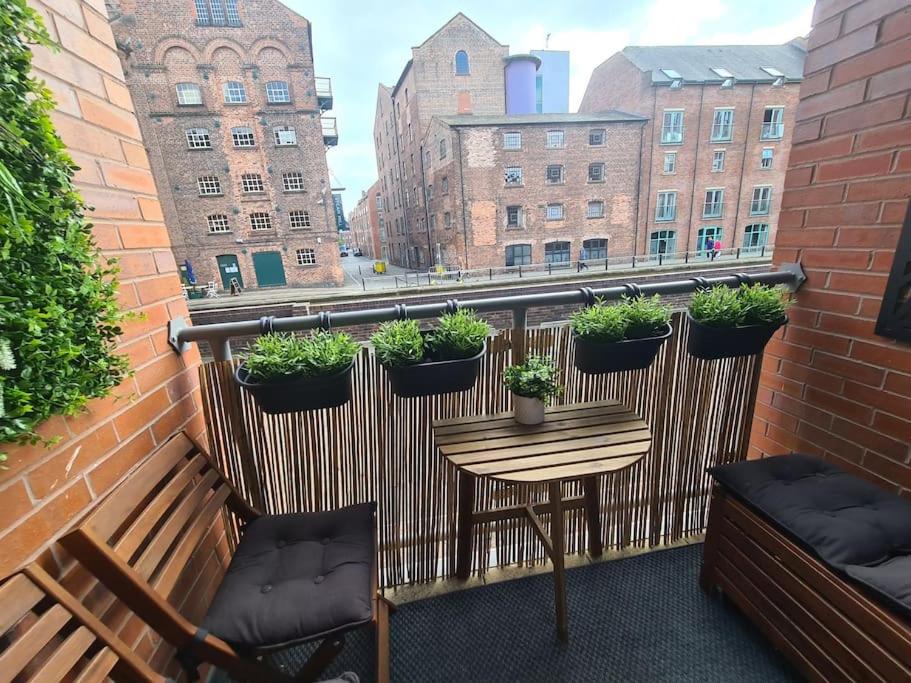 un balcone con tavolo e piante in vaso. di Stylish & recently refurbished Chester apartment - Up to 6 a Chester