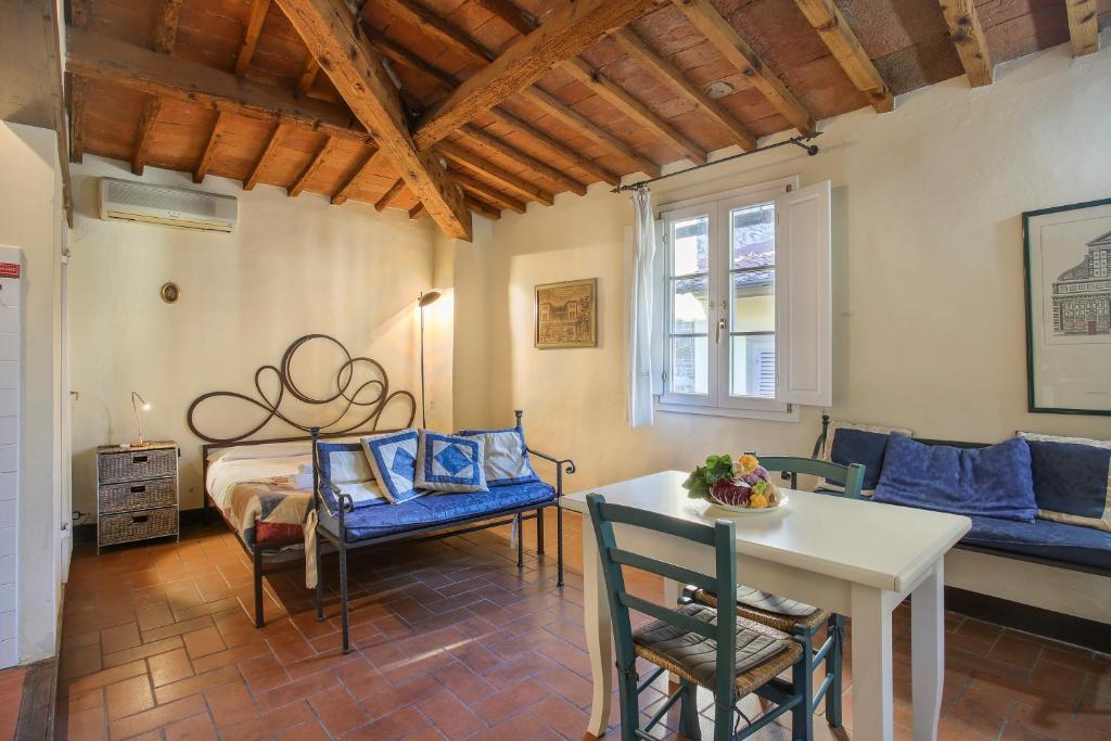 un salon avec un lit, une table et des chaises dans l'établissement La Torre di Dante, à Florence