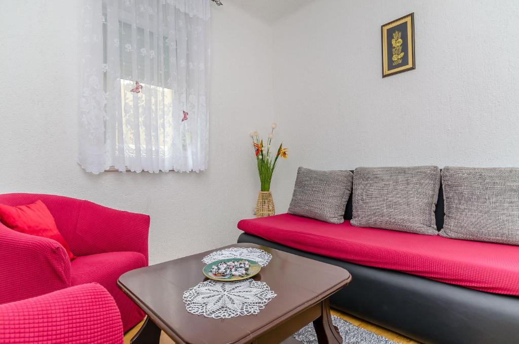a living room with a red couch and a table at Apartment Olga in Trogir