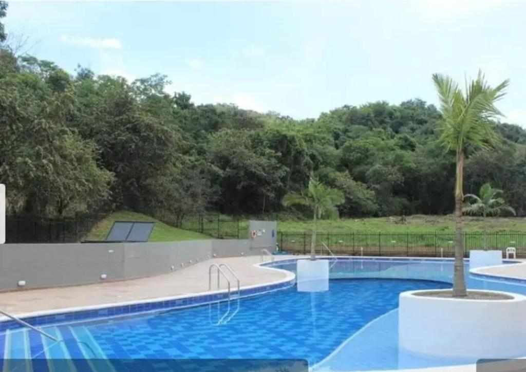 a large swimming pool in a yard with trees at Moderno apartamento cerca a la naturaleza in Villeta